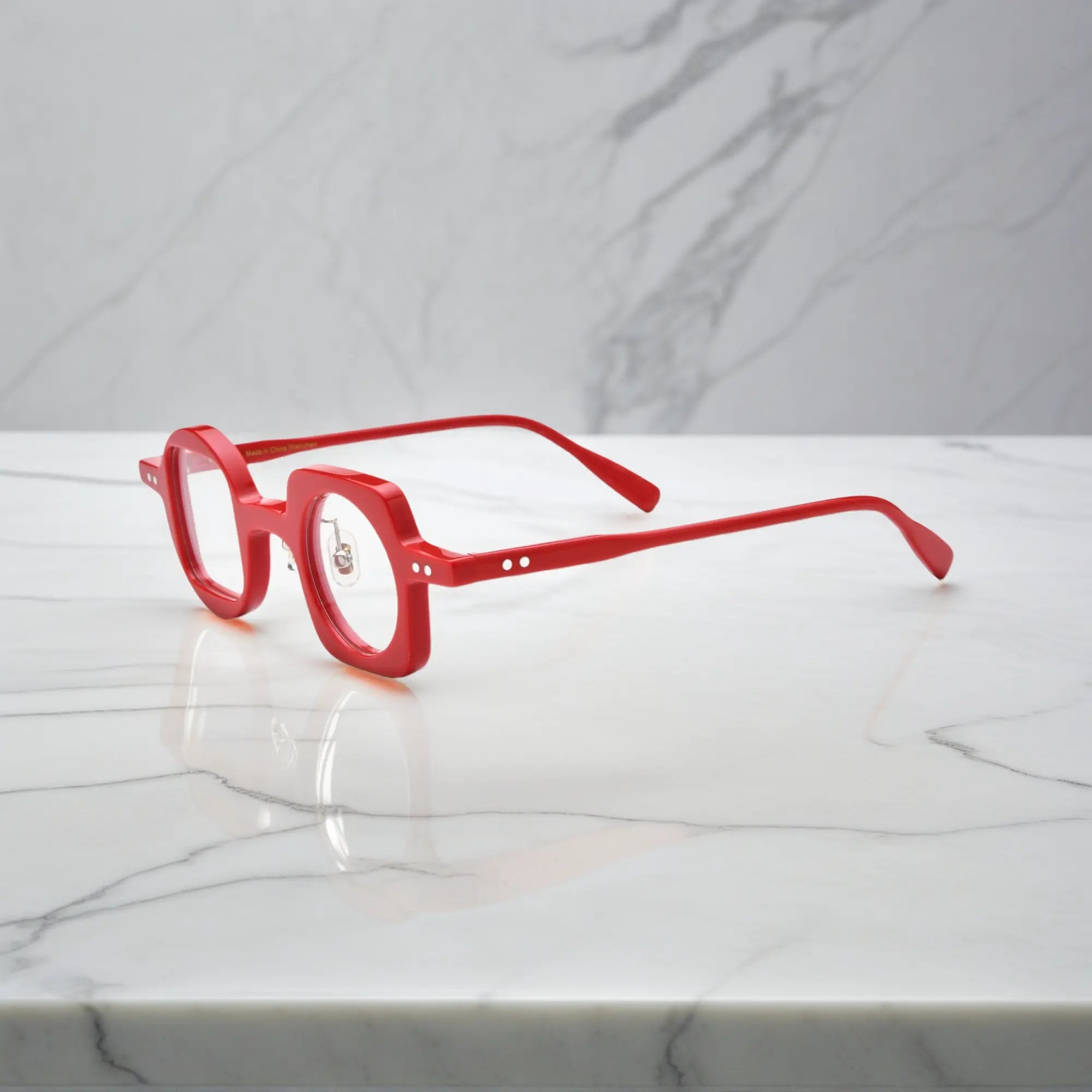 Side angle showcasing VoyueLens red asymmetrical glasses with silicone nose pads and premium acetate construction.